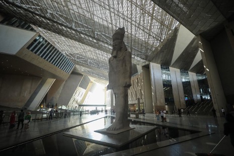 A view of the main atrium with a statue of Ramses II as people visit the Great Egyptian Museum